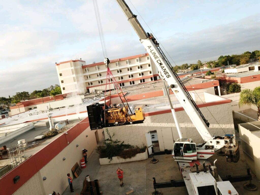 crane lifting machinery onto a roof