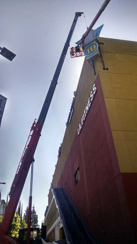 mobile crane with man basket changing 24 hour fitness sign in los angeles