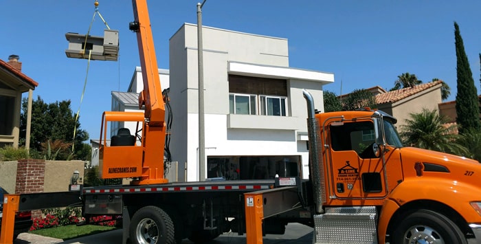 construction crane lifts modular building at construction site in southern california