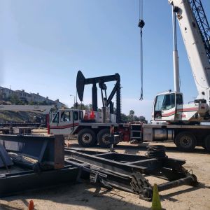 Crane moving oil derricks in orange county